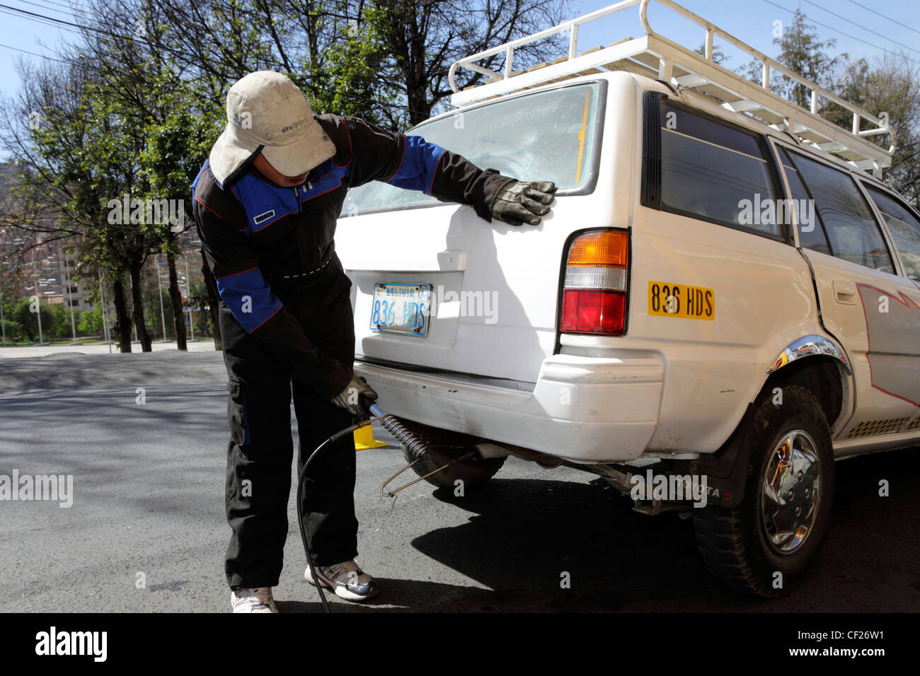 Ein Mechaniker testet die Abgasemissionen eines weißen Toyota SUV-Autos während der Clean Air Week (eine Kampagne zur Verringerung der Luftverschmutzung) in La Paz, Bolivien Stockfoto