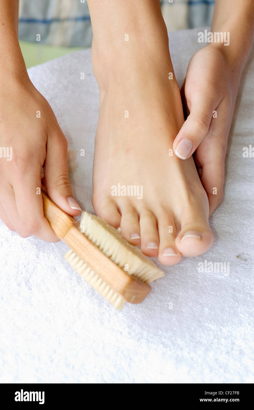 Weibliche Bürsten Zehen mit Fuß-Pinsel Stockfoto