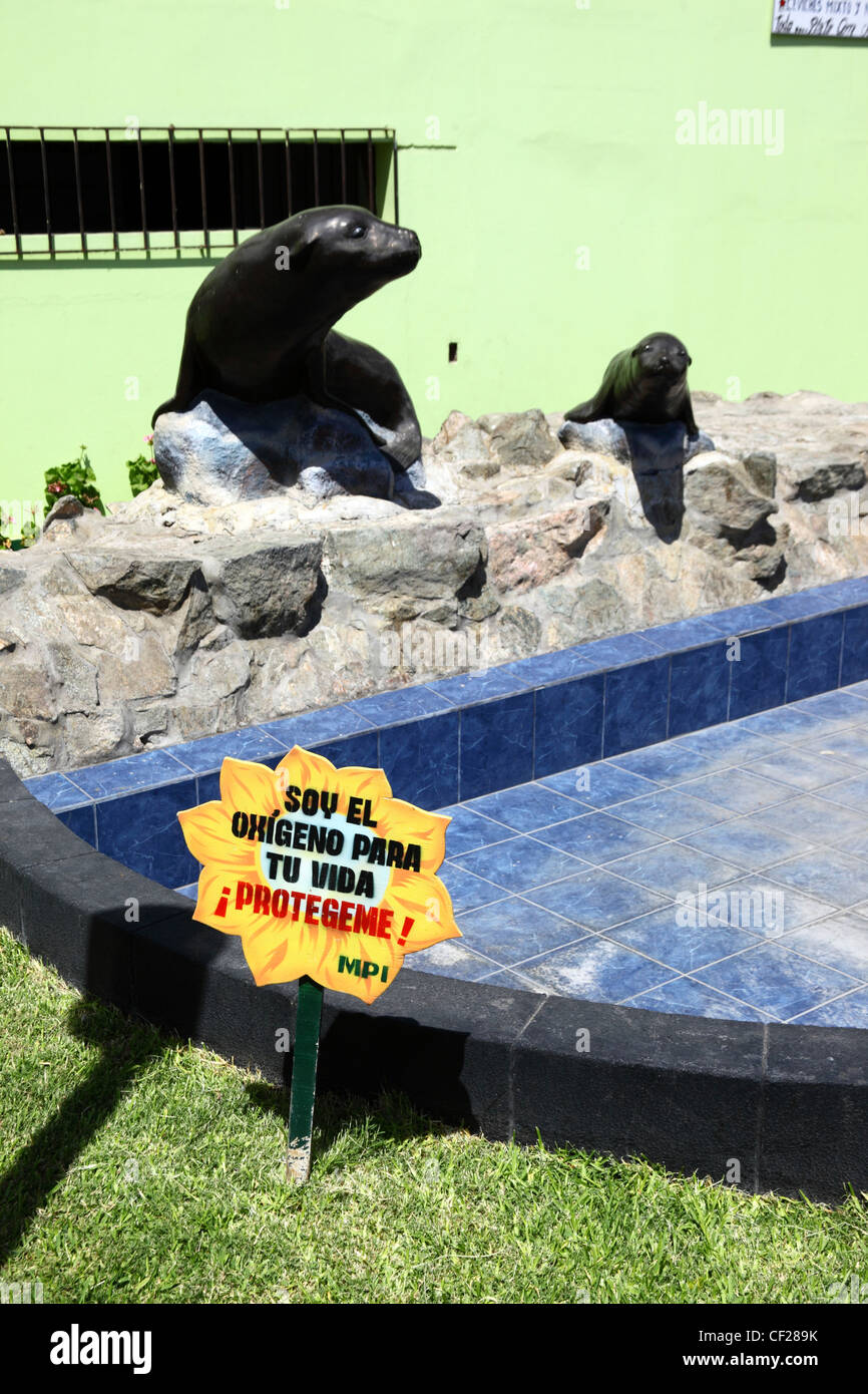 Sea Lion Statue und Blume mit Slogan die Menschen ermutigen, kümmern uns um die Umwelt, Ilo, Peru Stockfoto