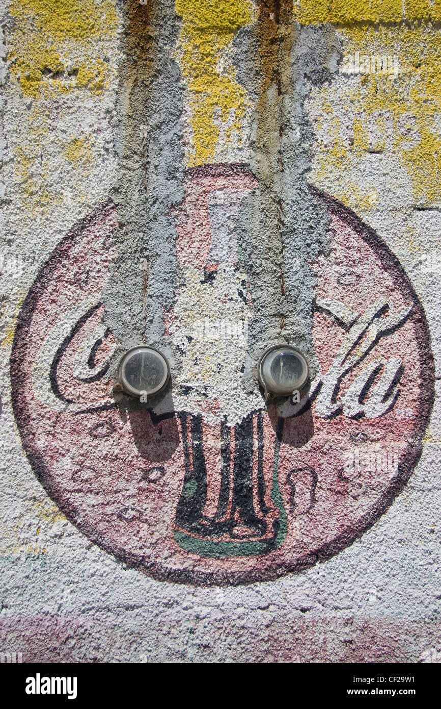 Eine sich verschlechternde Coca-Cola Company Logo und Flasche in einem Stuck Wand gemalt Stockfoto