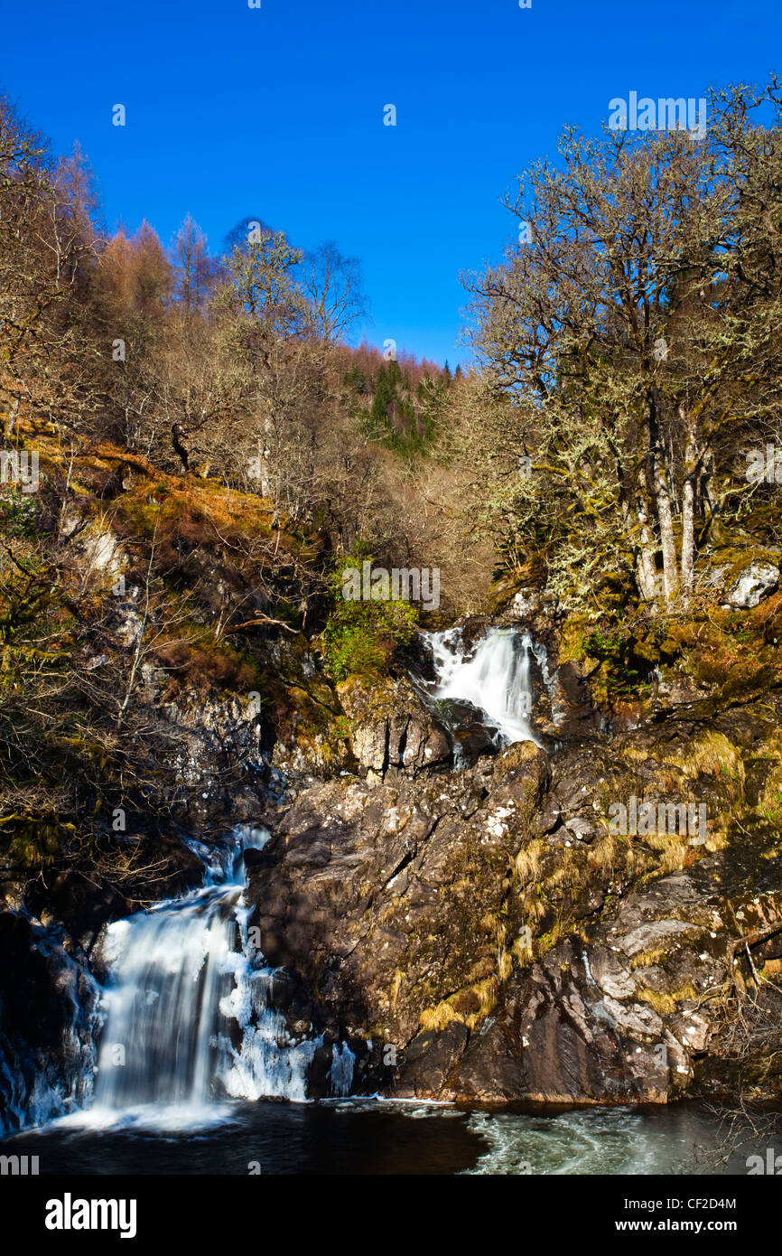 Die Eas Chia-Aig Wasserfall läuft durch eine ruhige Fläche des heimischen Waldes. Stockfoto