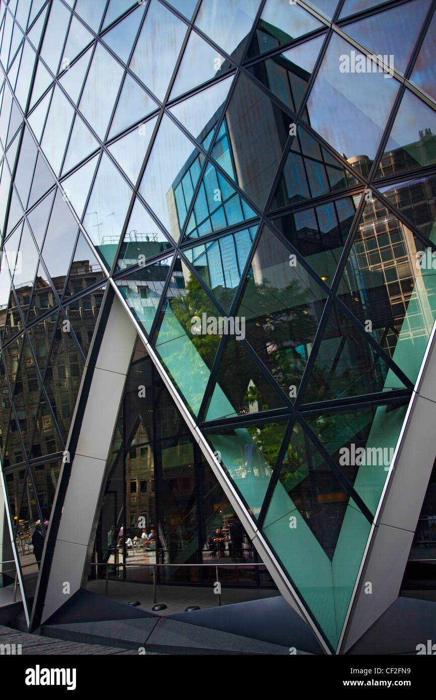 Umliegende Gebäude spiegelt sich in der Glasfassade des 30 St Mary Axe, bekannt als die Gurke in London der traditionellen finanziellen Stockfoto
