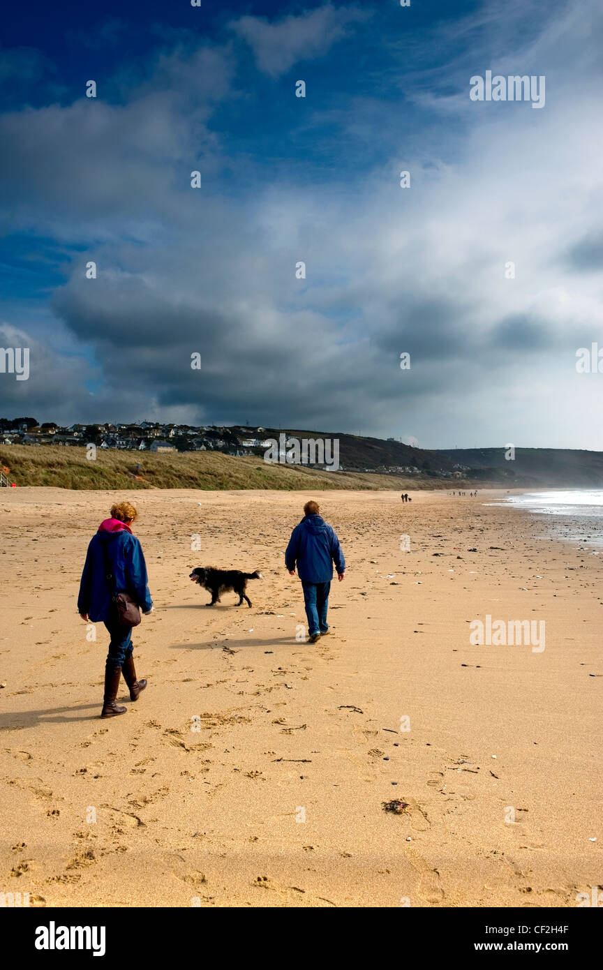 Ein paar zu Fuß ihren Hund auf felsfreie Sands. Stockfoto