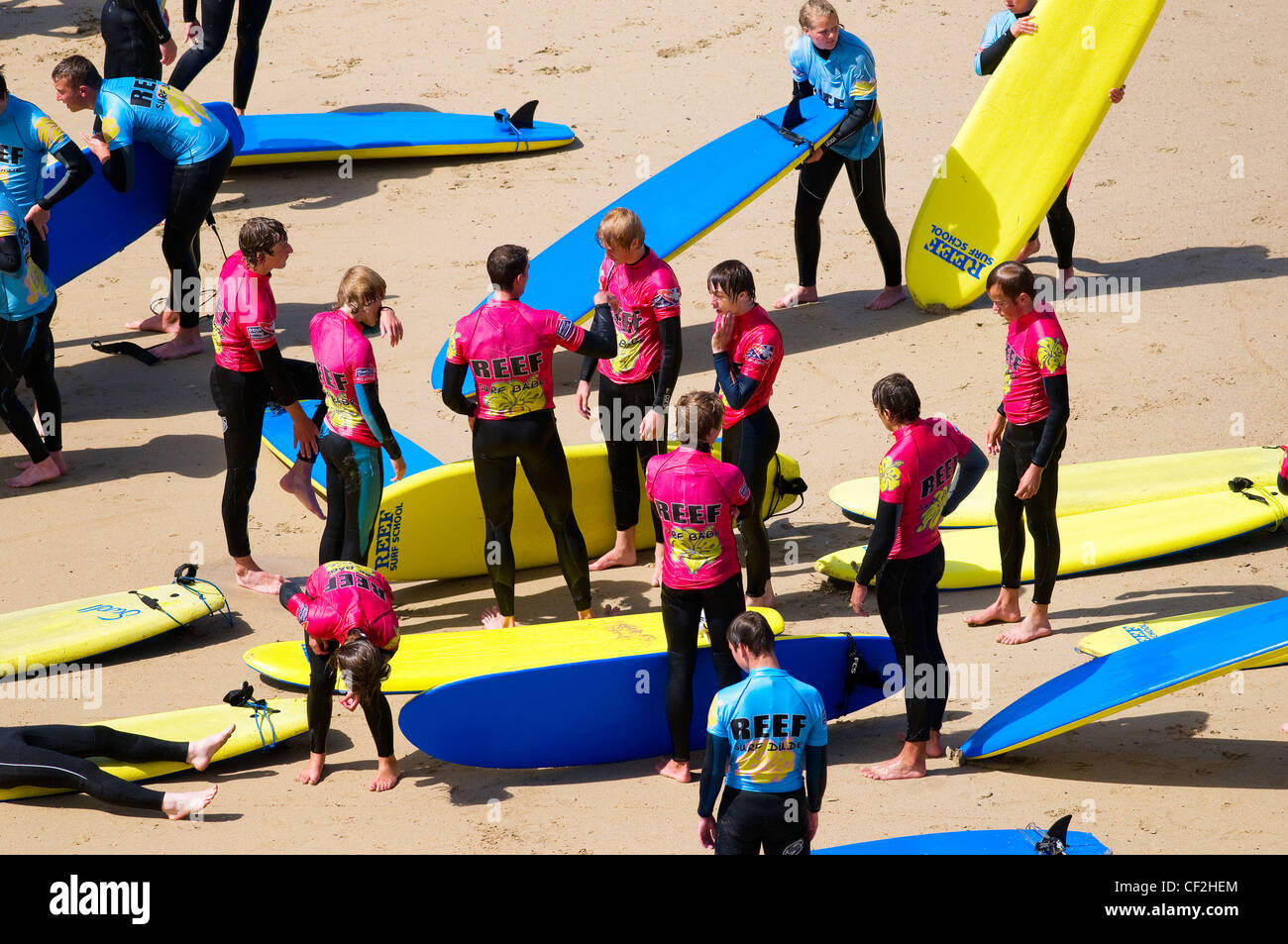 Junge Menschen erhalten Anweisungen an eine Surfschule am Strand in Newquay. Stockfoto