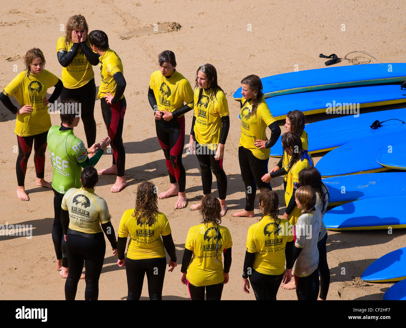Junge Menschen erhalten Anweisungen an eine Surfschule am Strand in Newquay. Stockfoto