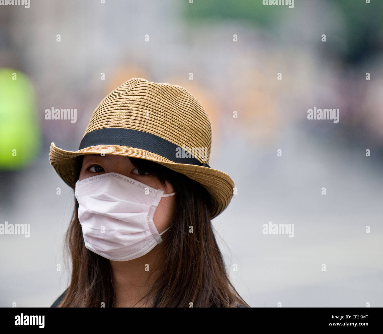 Eine junge Frau trägt eine Gesichtsmaske, um sich zu schützen gegen die Schweinegrippe zu fangen. Stockfoto