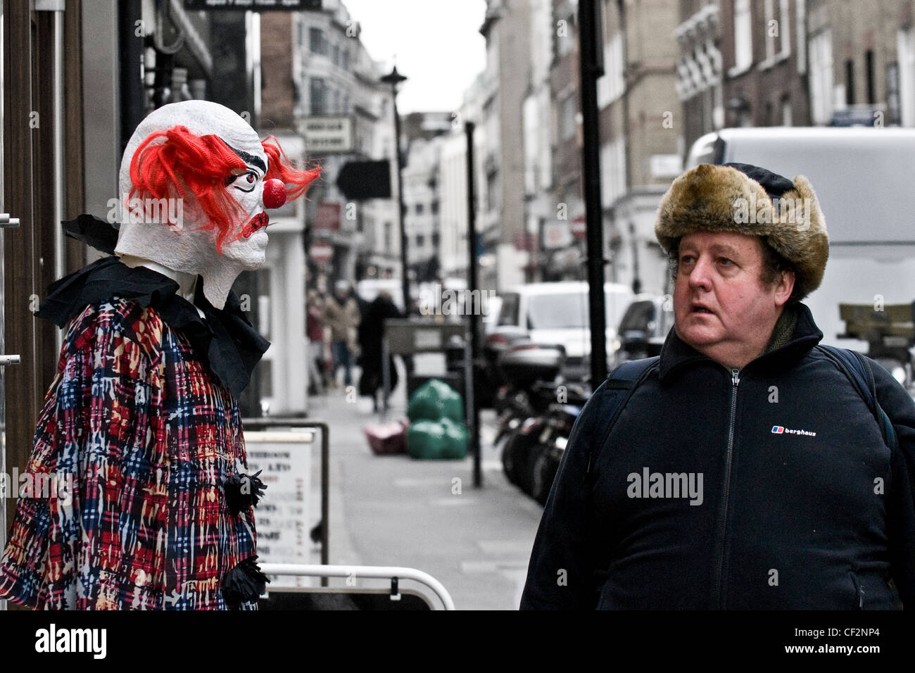 Ein Fußgänger betrachten ein Dummy als beängstigend Clown verkleidet. Stockfoto