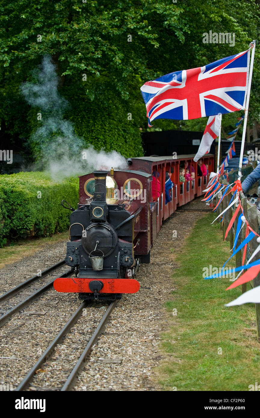 Eine Miniatur Dampfmaschine ziehen Kutschen mit Passagieren an Audley End Miniatur-Eisenbahn. Stockfoto