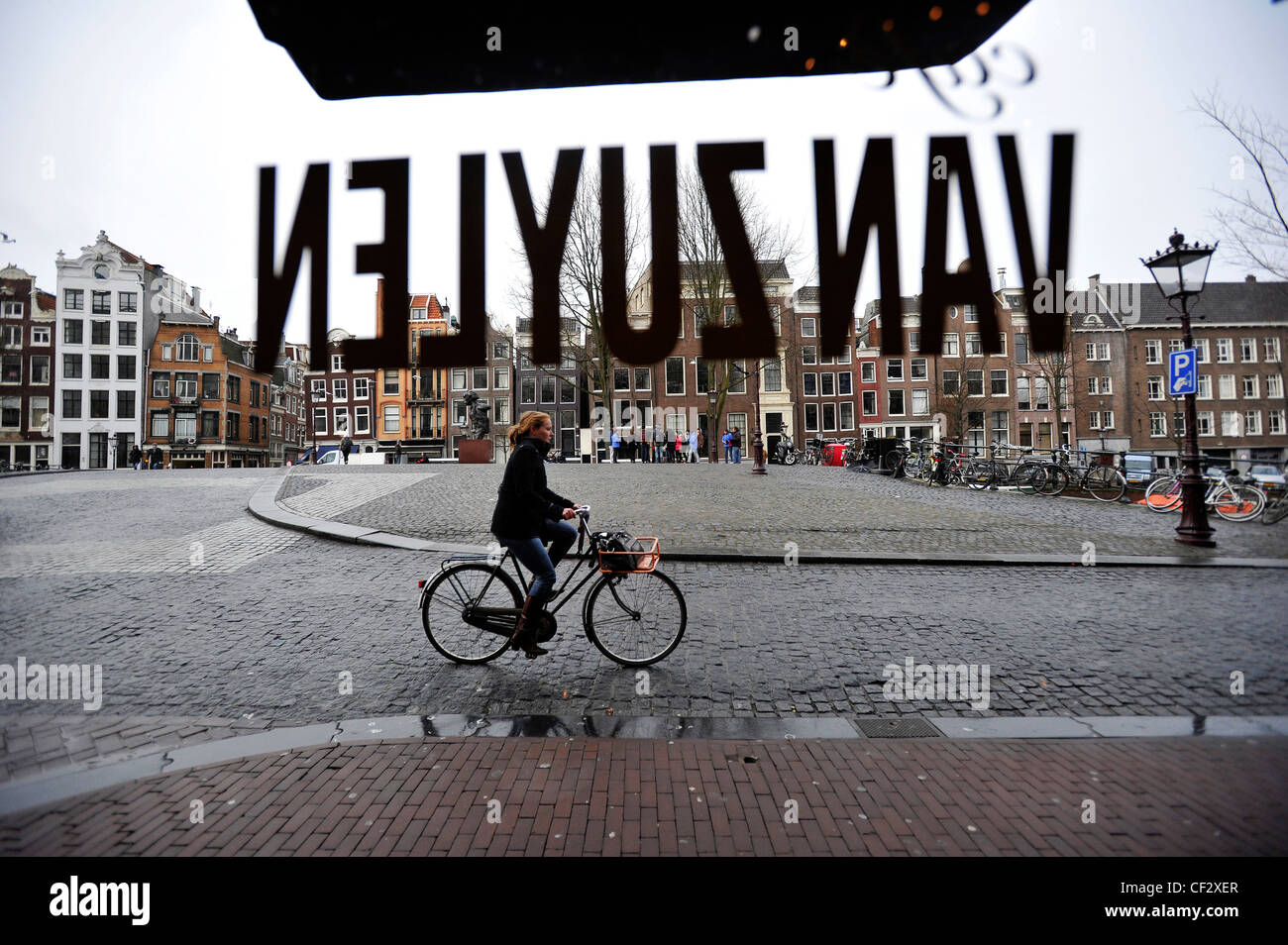 Ein Radfahrer fährt vorbei an das Fenster des Café Van Zuylen in Amsterdam, Niederlande. Stockfoto