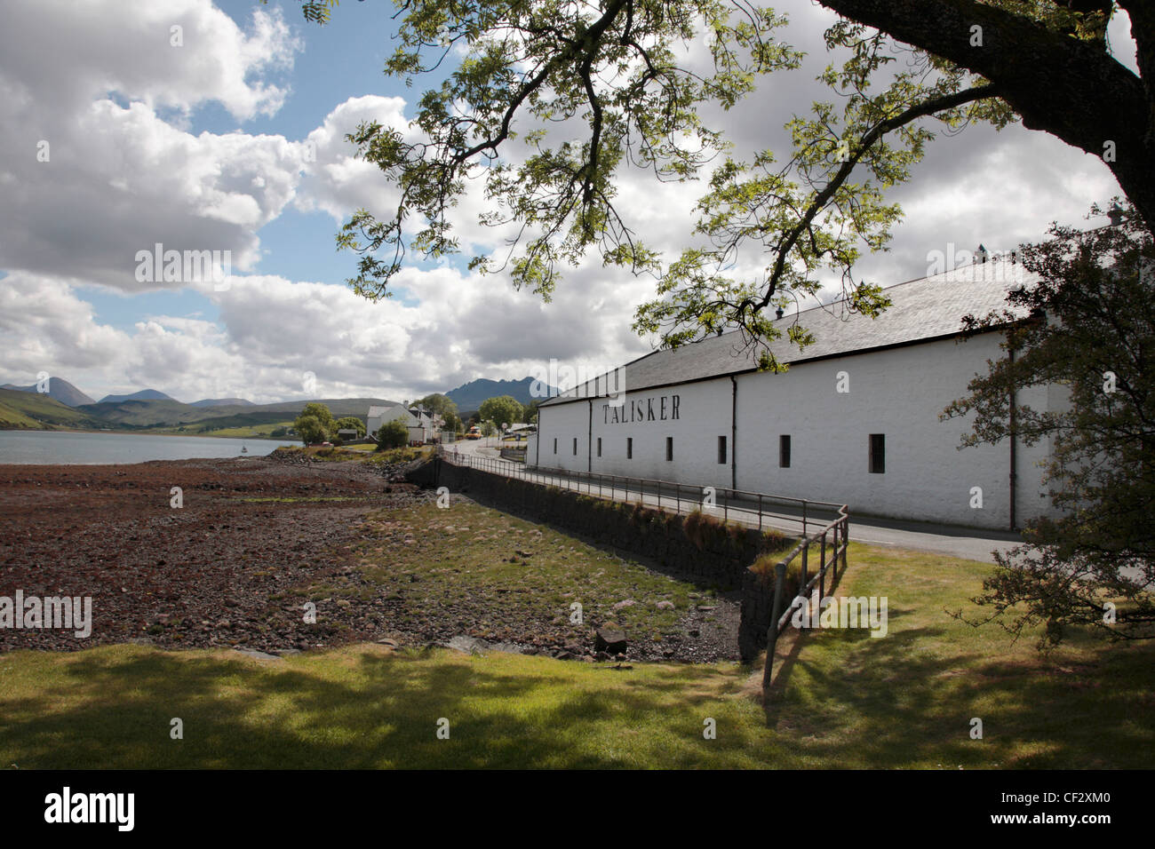 Talisker Whiskybrennerei in Carbost am Ufer des Loch Harport mit atemberaubenden Blick auf den Cullins auf der Isle Of Skye. Stockfoto