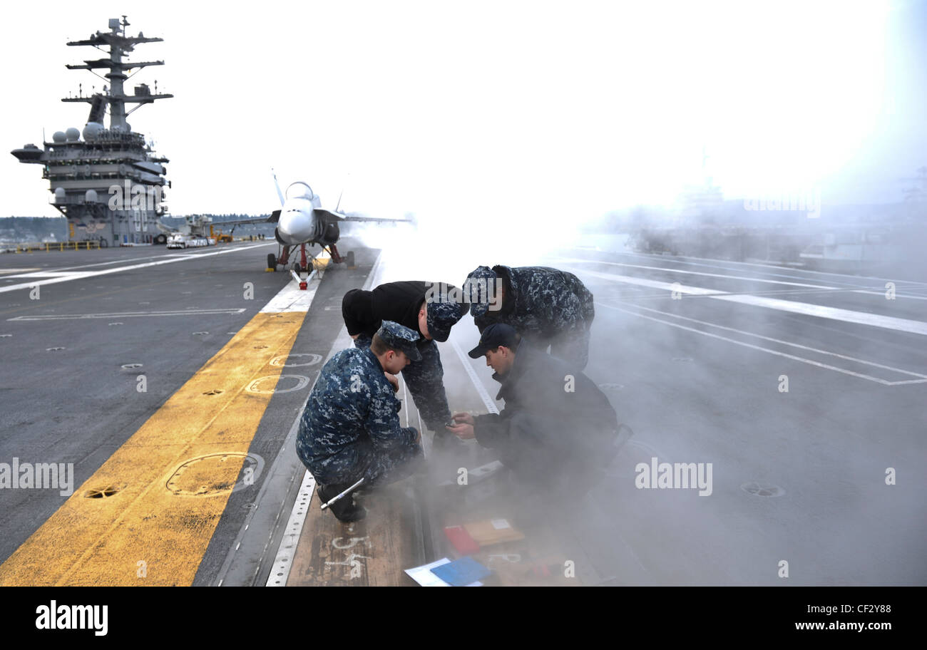 BREMERTON, Washington (Feb 28, 2012) – Aviation Boatswains Mate (Ausrüstung) 1. Klasse Scott Skeate, Aviation Boatswains Mate (Ausrüstung) 1. Klasse Darryl Johnson, Aviation Boatswains Mate 2. Klasse Luke Hart und Airman Apprentice McCord Brickle führen Wartung an einem Taillenkatapult Shuttle auf dem Flugdeck des Flugzeugträgers USS Nimitz (CVN 68) durch. Die Wartung ist Teil der kontinuierlichen Bemühungen von Nimitz, sich auf die See vorzubereiten. Nimitz bereitet sich auf die Rückkehr ins Meer vor. Stockfoto