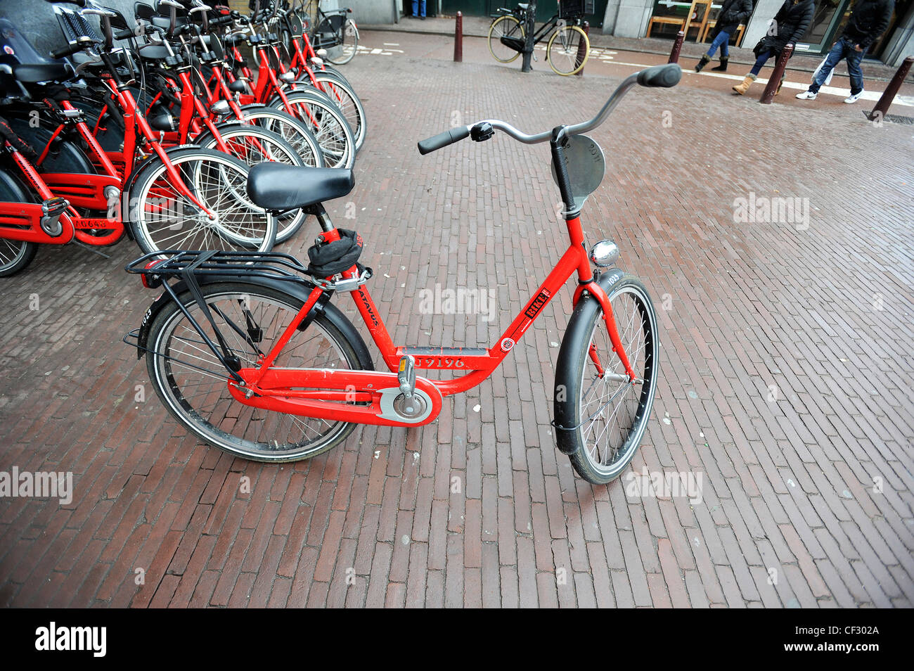 Eine typische rote Leihfahrrad vor einem Geschäft in Amsterdam, Niederlande. Stockfoto