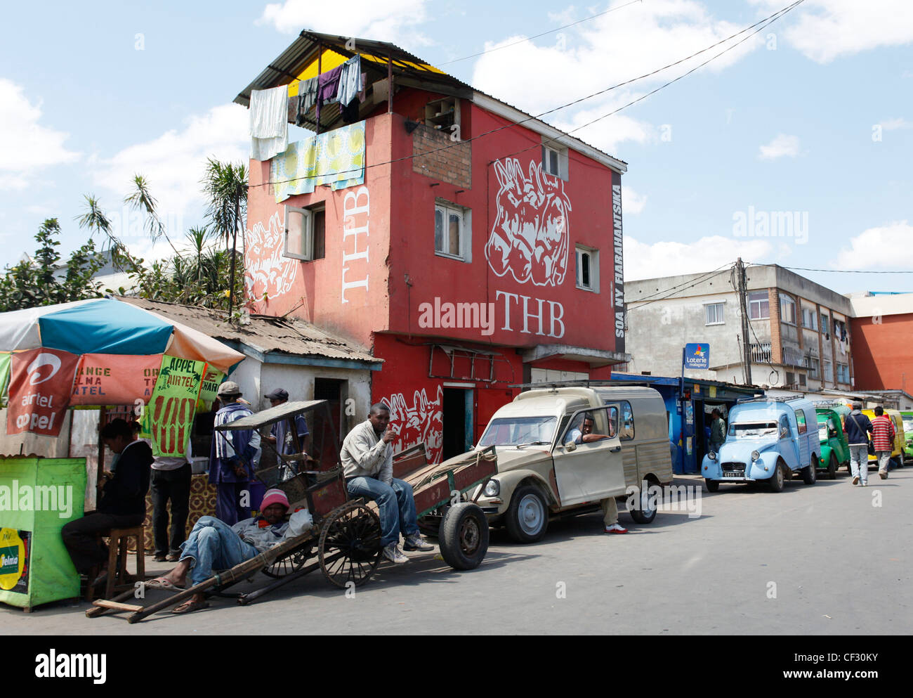 Träger und Straßenszene mit lokalen Bar THB Bier Antananarivo werben rot lackiert. Madagaskar. Stockfoto