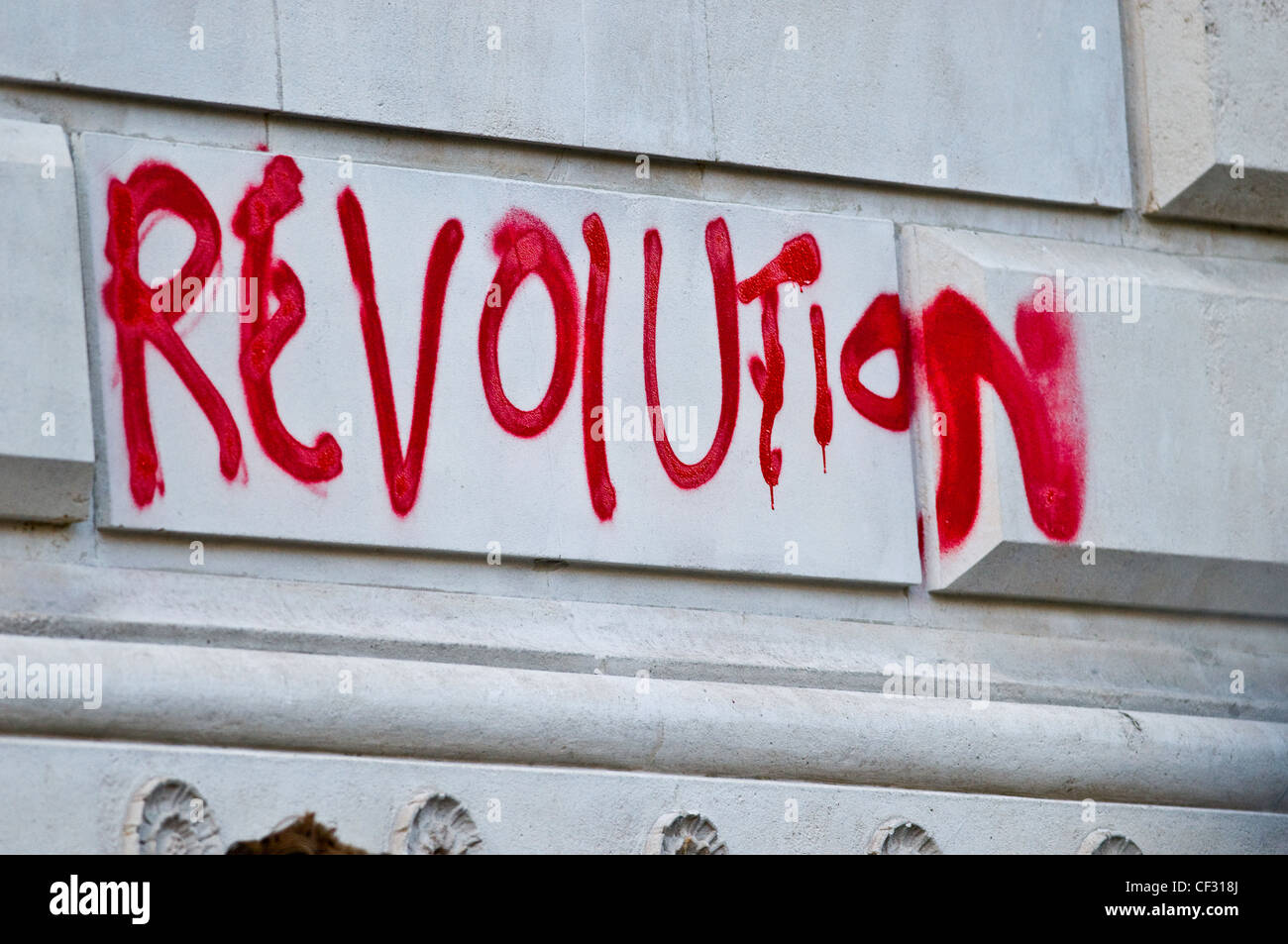 "Revolution" in roter Sprühfarbe auf eine Wand geschrieben. Stockfoto