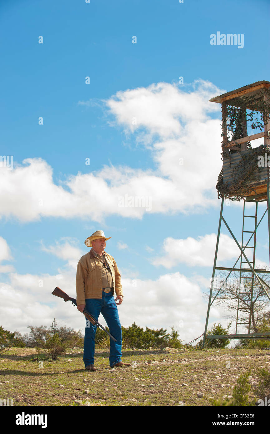 Amerikanischer Mann mit Waffe stehen neben Jagd stand Stockfoto