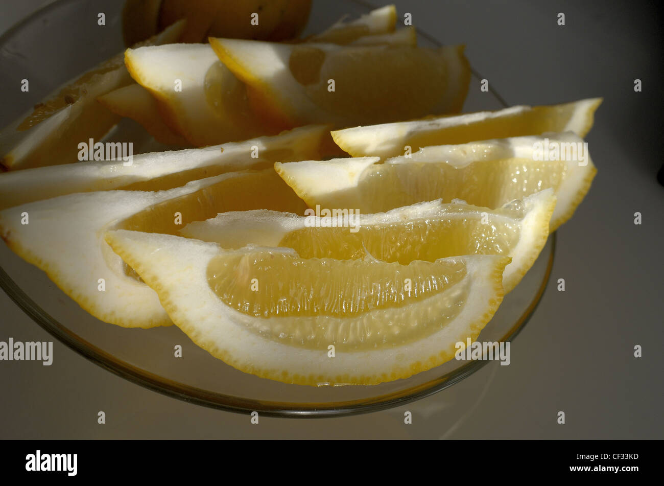 Frisch geschnittene sonnenüberfluteten Zitronen auf einem Teller Stockfoto