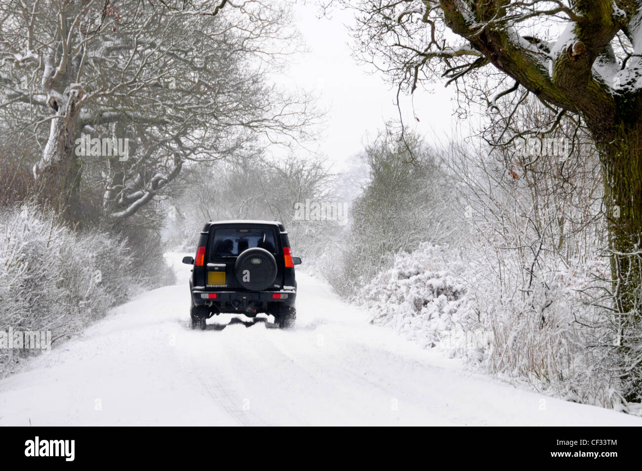 Land Rover Discovery getrieben entlang Schnee bedeckten Feldweg (verdeckt Nummer Platte & Händler Name entfernt) Stockfoto