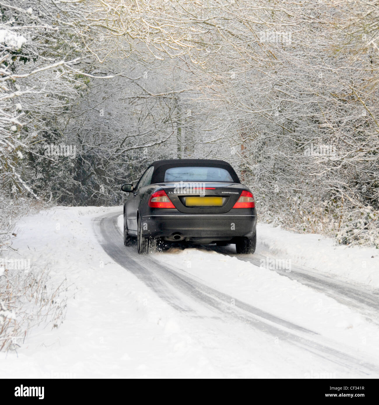 Mercedes-Benz CLK 200 Coupé Cabrio fahren auf Schnee bedeckten Land Lane (verdeckt Nummernschild) Stockfoto
