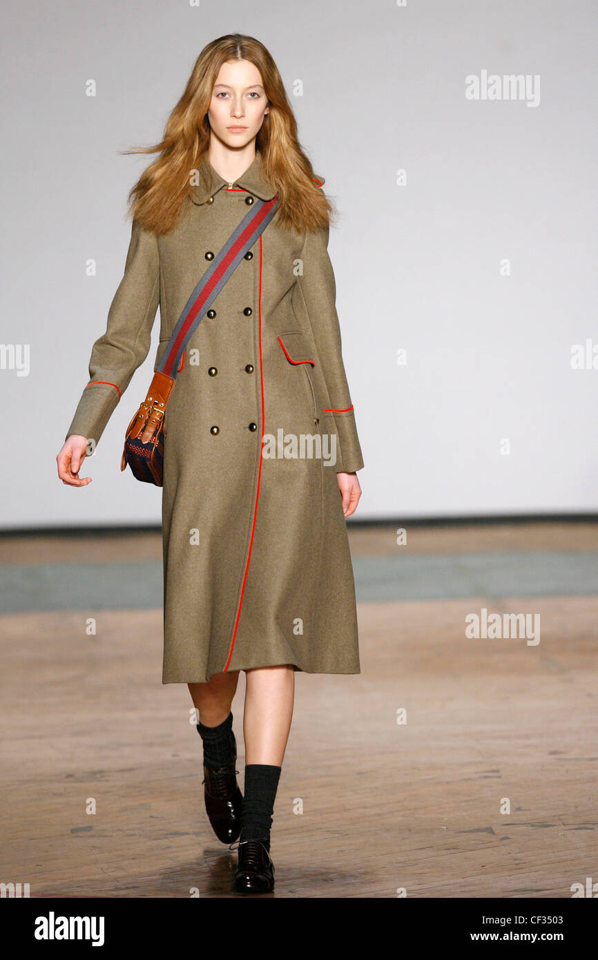 Eine military-Look Khaki double breasted unterhalb der Knie wollenen Mantel Messingknöpfe, leuchtend rote Einfassung und Epauletten auf den Stockfoto Eine military-Look Khaki double breasted unterhalb der Knie wollenen Mantel Messingknöpfe, leuchtend rote Einfassung und Epauletten auf den Stockfoto