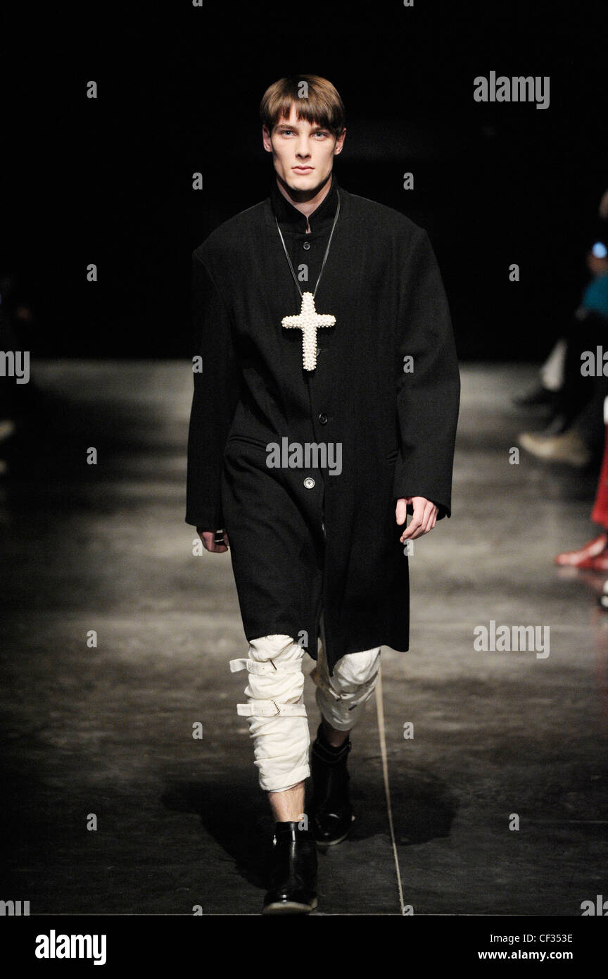 Blaak Paris bereit zu tragen Menswear Herbst Winter schwarz Knie Länge  Mantel, weißes Kreuz an der Kette, weiße Hose Riemen auf Knien  Stockfotografie - Alamy