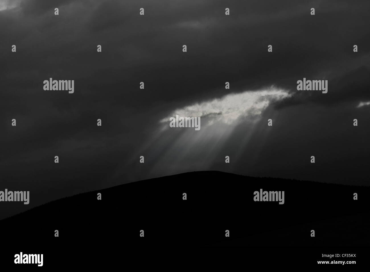 Wellen von Licht durch dunkle Gewitterwolken in Glenlivet. Stockfoto