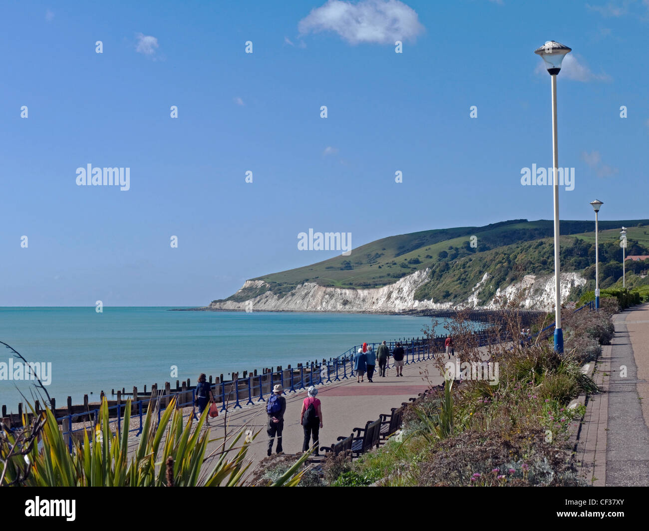 Menschen Flanieren entlang der westlichen Promenade in Eastbourne mit Blick auf den South Downs. Stockfoto