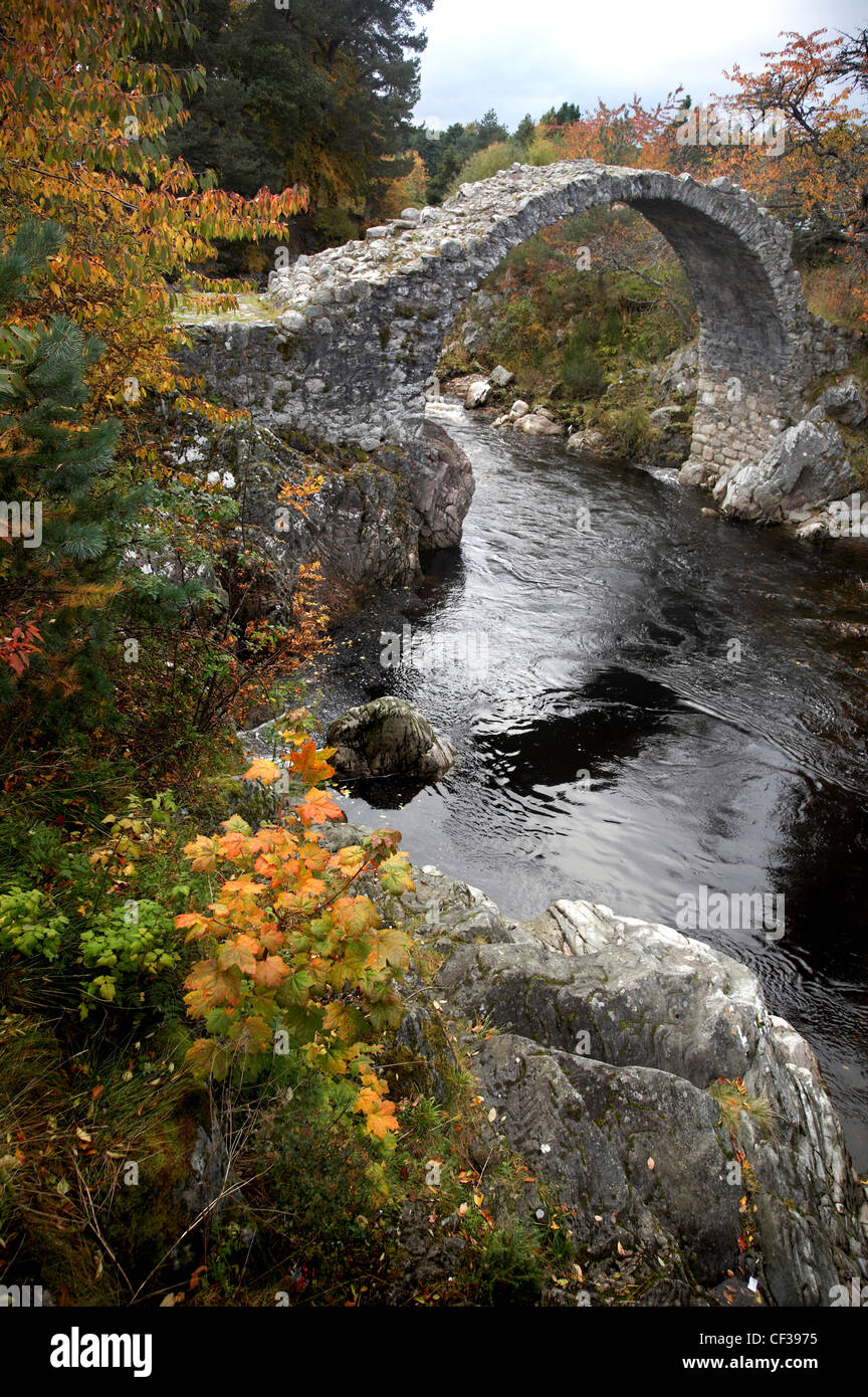 Einen flachen Fluß unter einer alten Brücke der Lastesel in Carrbridge. Stockfoto