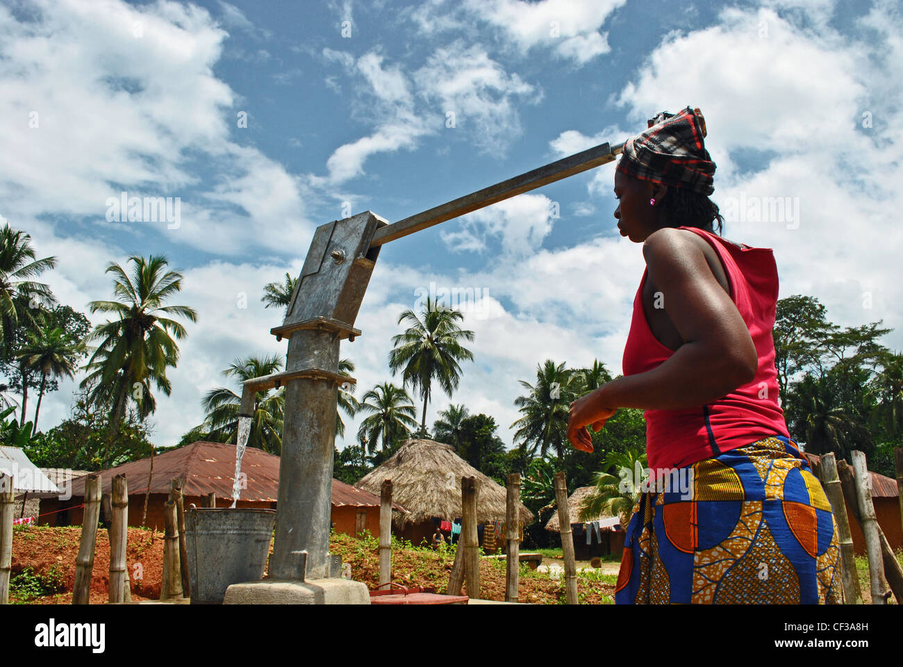 Eine Frau pumpt Wasser aus einem Brunnen in einem Dorf in der Nähe von Kenema, Sierra Leone Stockfoto