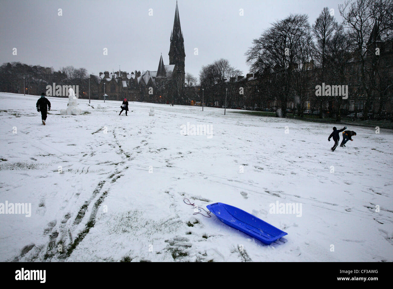 Jungs spielen in Bruntsfield Links in die Altstadt von Edinburgh an einem verschneiten Nachmittag. Stockfoto