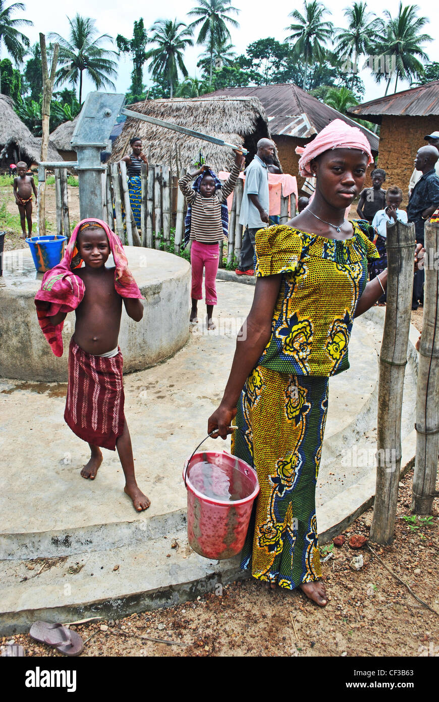 Kinder mit einer Handpumpe nun in einem Dorf in der Nähe von Kenema, Sierra Leone Stockfoto