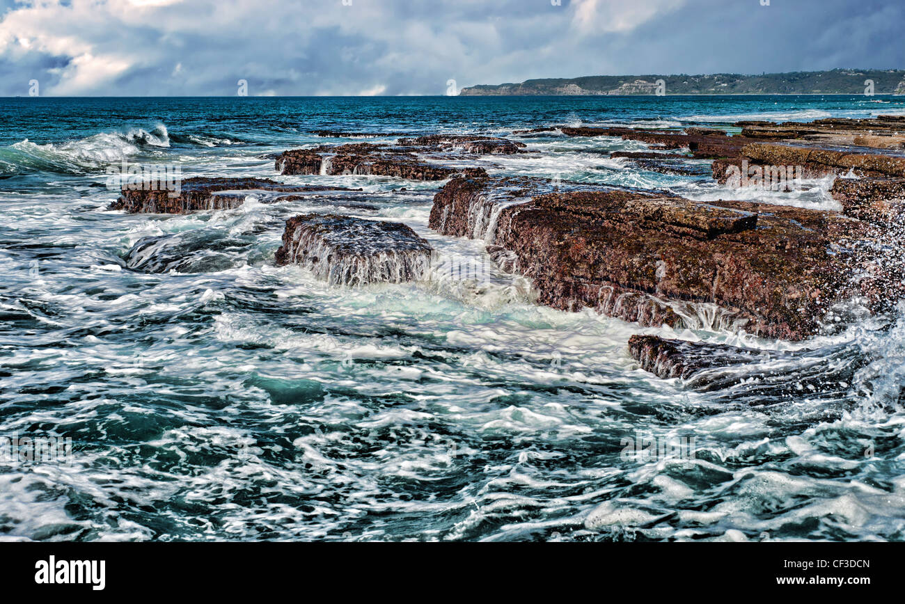 starke Wellen, die auf Felsen an der Küste Stockfoto