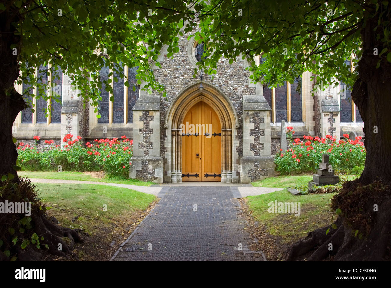 Baum gerahmt Pfad und die Tür zu einer alten englischen Kirche. Untersuchungen zufolge einer von zehn Menschen in Großbritannien besucht Kirche jede Woche Stockfoto