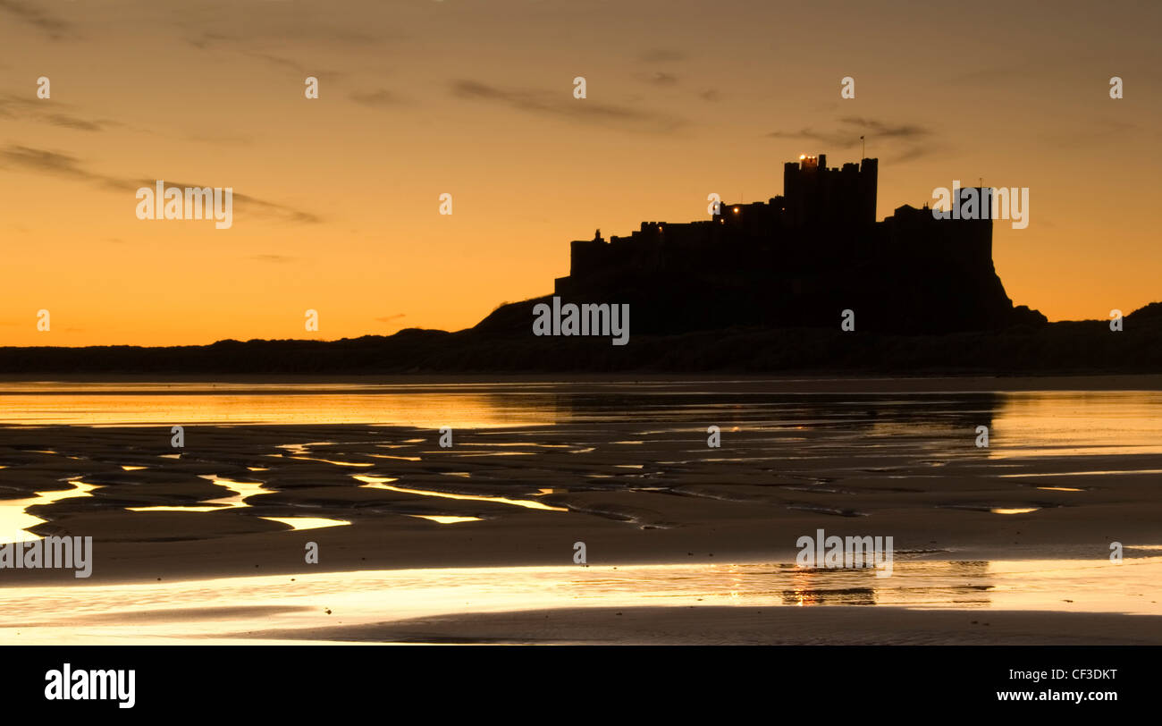 Eine Silhouette Ansicht von Bamburgh Castle in der Morgendämmerung. Das Schloss ist auf einem Basalt saß auf dem Rand der Nordsee bei Bamburgh ein Stockfoto