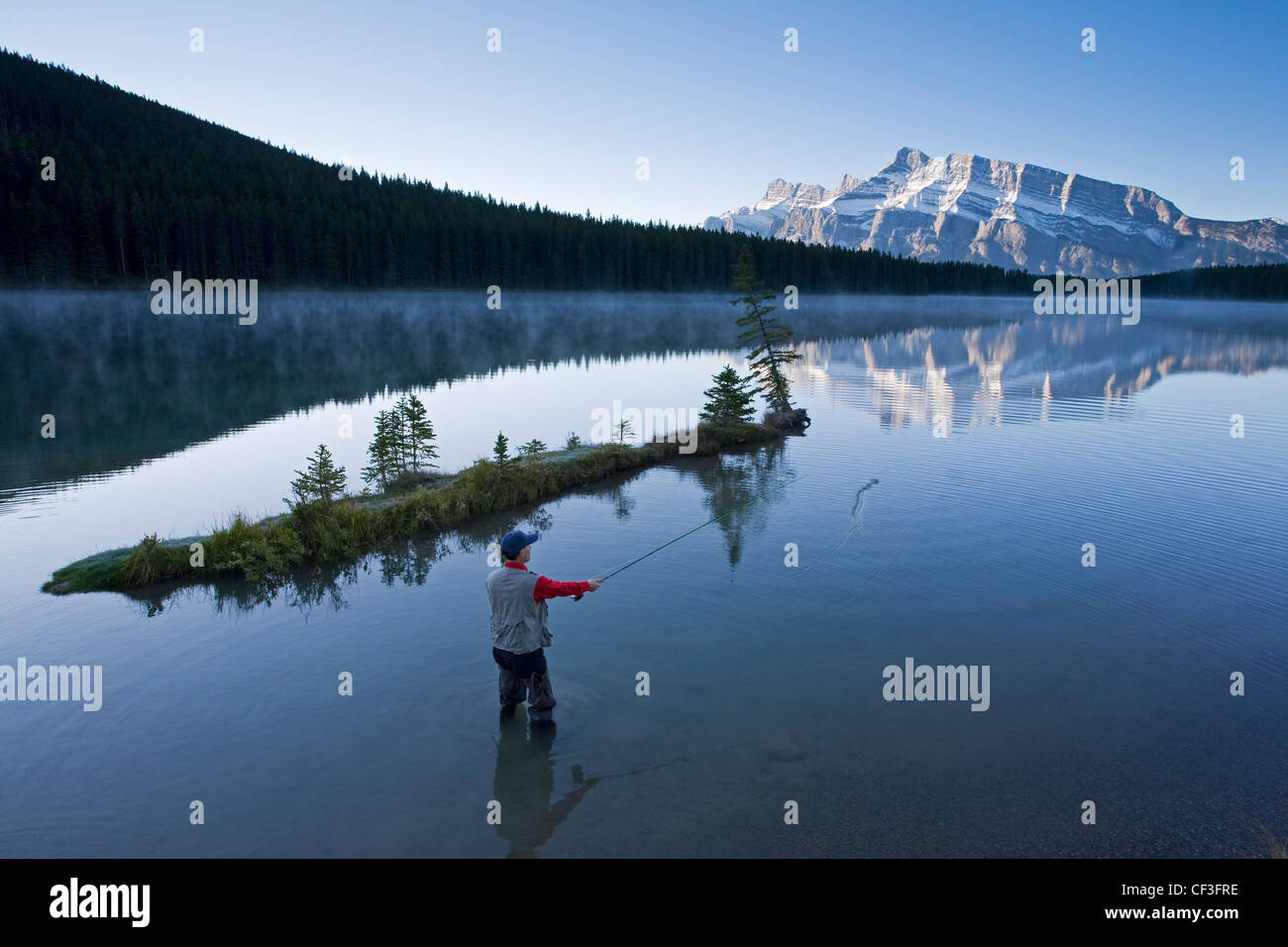 Applying männliche Fliege Fischen in zwei Jack Lake, Banff Nationalpark, Alberta, Kanada. Stockfoto