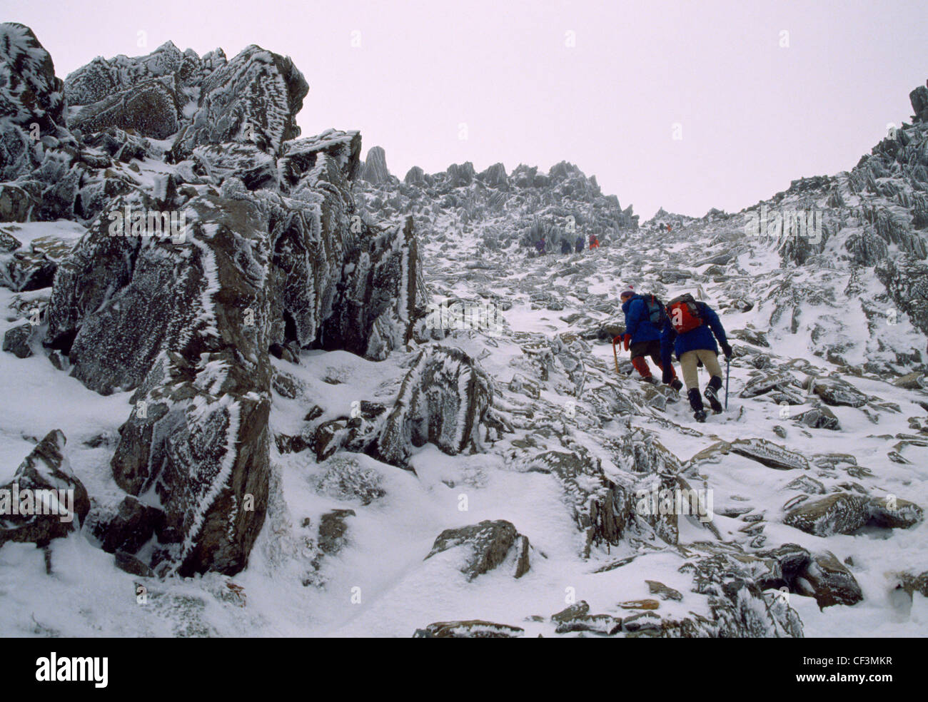 Wanderer in Schnee und Eis den Weg nach oben die Nordseite des Glyder Fach im Snowdonia National Park. Stockfoto