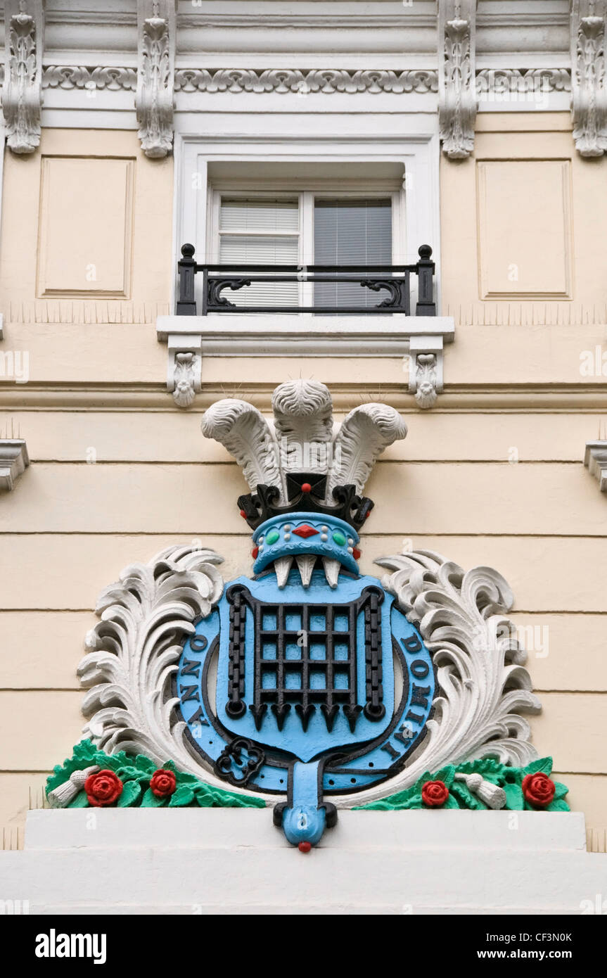 Eine Kartusche Wappen mit einer Durchsuchung Fallgatter übergestiegen durch den Prince Of Wales Federn über Moss Bros in der King Street, Cov Stockfoto