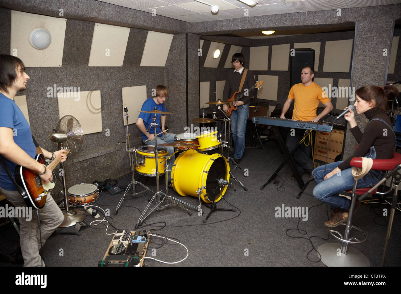 eine nachdenkliche Rockband. traurige Sänger Mädchen, zwei Musiker mit Elektro-Gitarren und einen Schlagzeuger im Studio arbeiten. Stockfoto