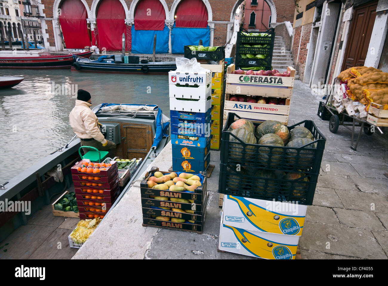 Ein Mann entlädt Obst und Gemüse aus seinem Boot am Markt von Rialto - Venedig, Venezia, Italien, Europa Stockfoto