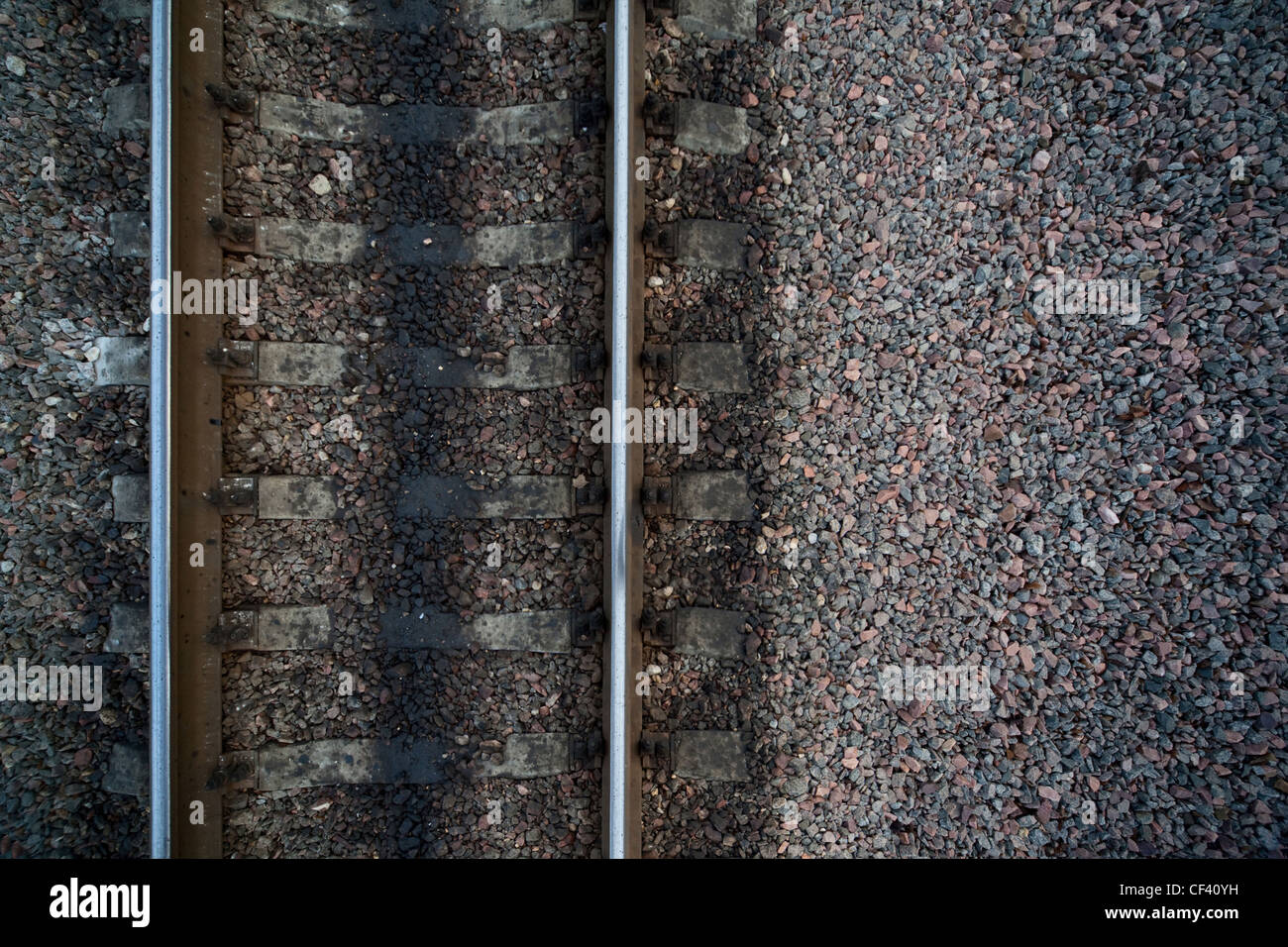 Schienen und Kreuz Bande der Eisenbahn unter Steinen auf der linken Seite Stockfoto