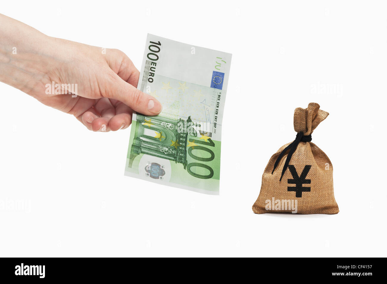 Ein 100 Euro-Schein ist in der Hand gehalten. In der Nähe ist ein Geldbeutel mit einem japanischen Yen Währungszeichen. Stockfoto