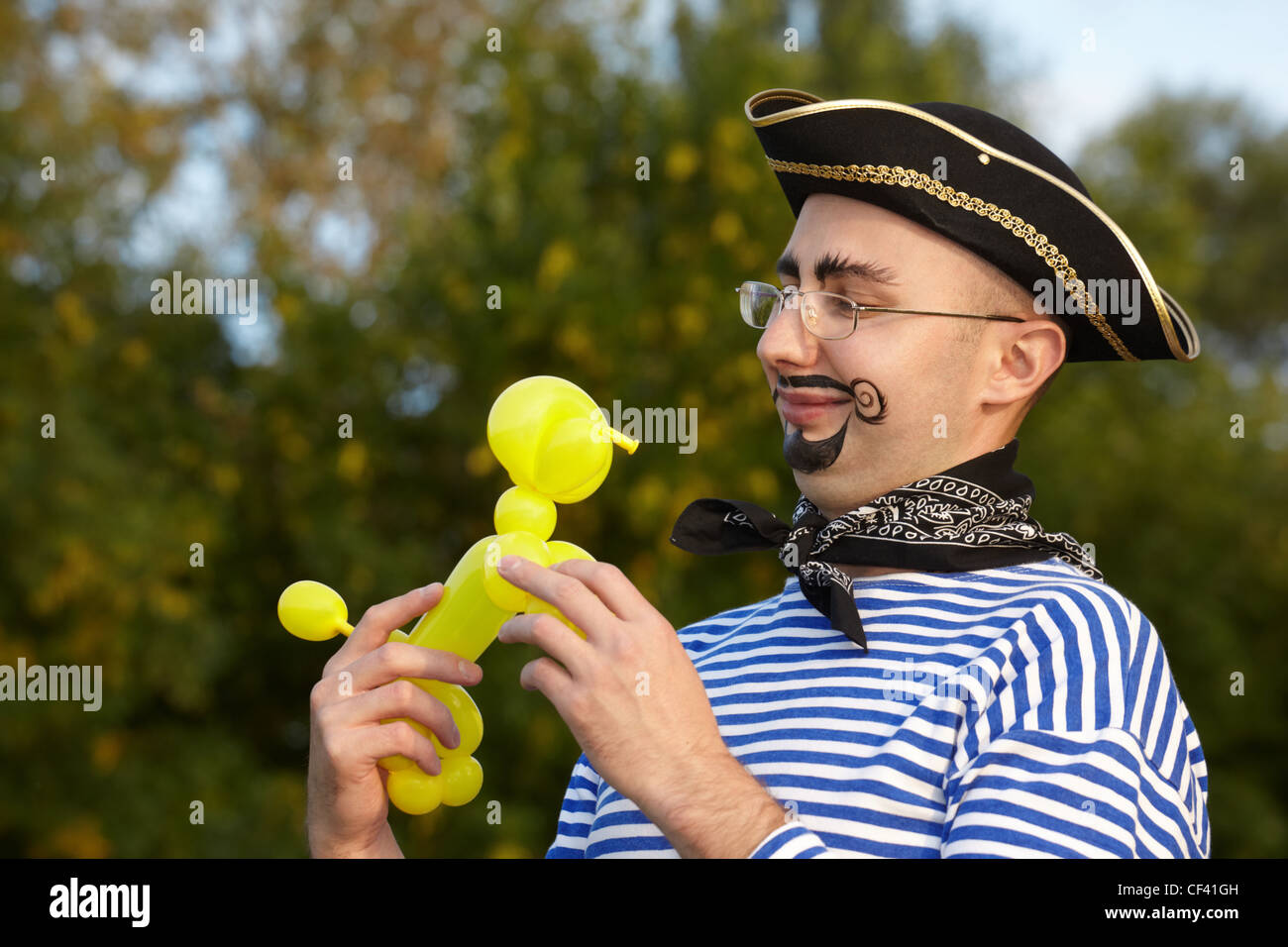 lächelnden Mann Piraten Anzug Doggy Luft-Ballon zu betrachten. Stockfoto