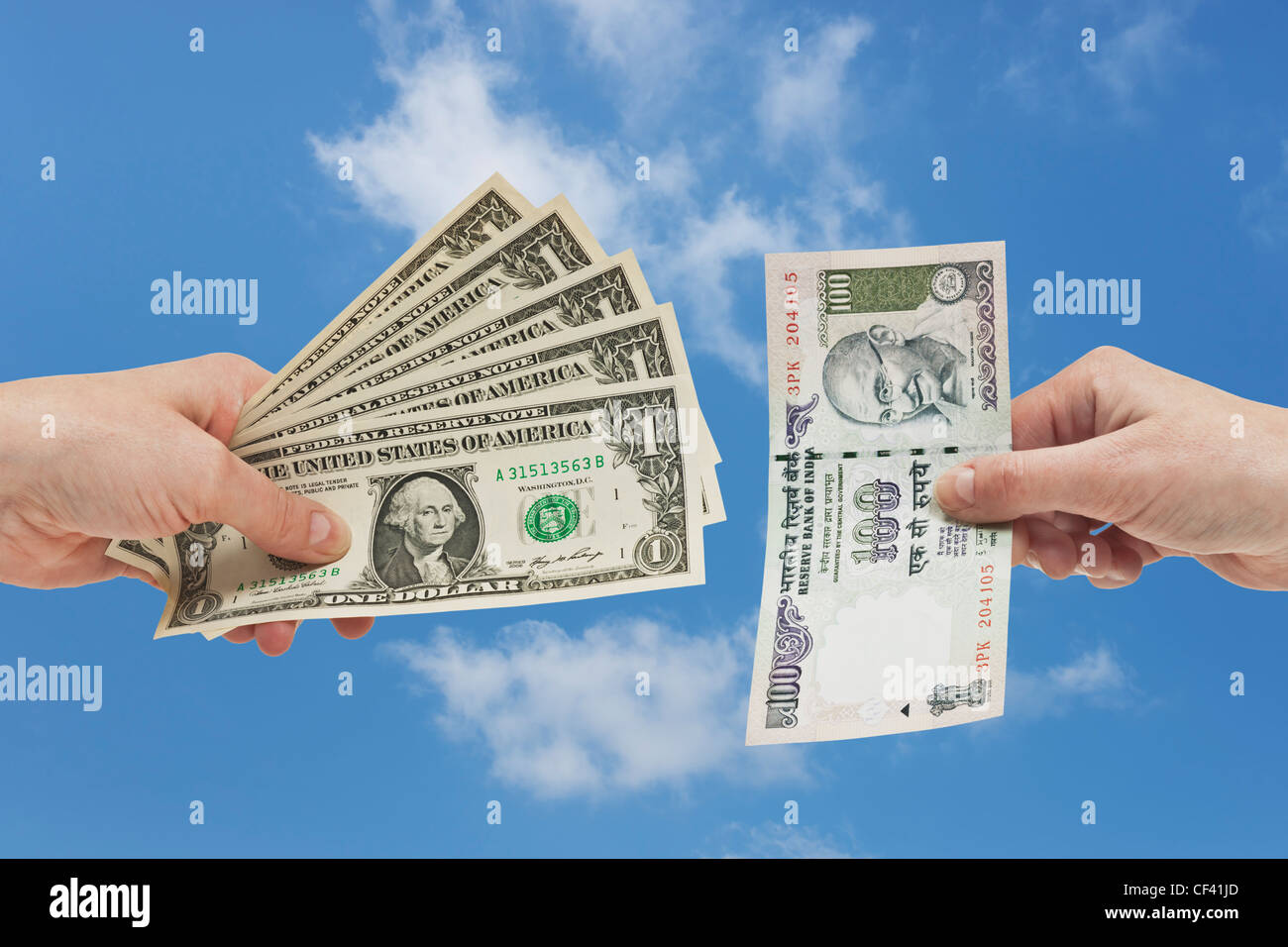 Fünf 1 US-Dollar-Scheine in der Hand gehalten werden. Auf der anderen Seite ist eine indische 100 Rupien Rechnung in der Hand, Hintergrund Himmel gehalten. Stockfoto