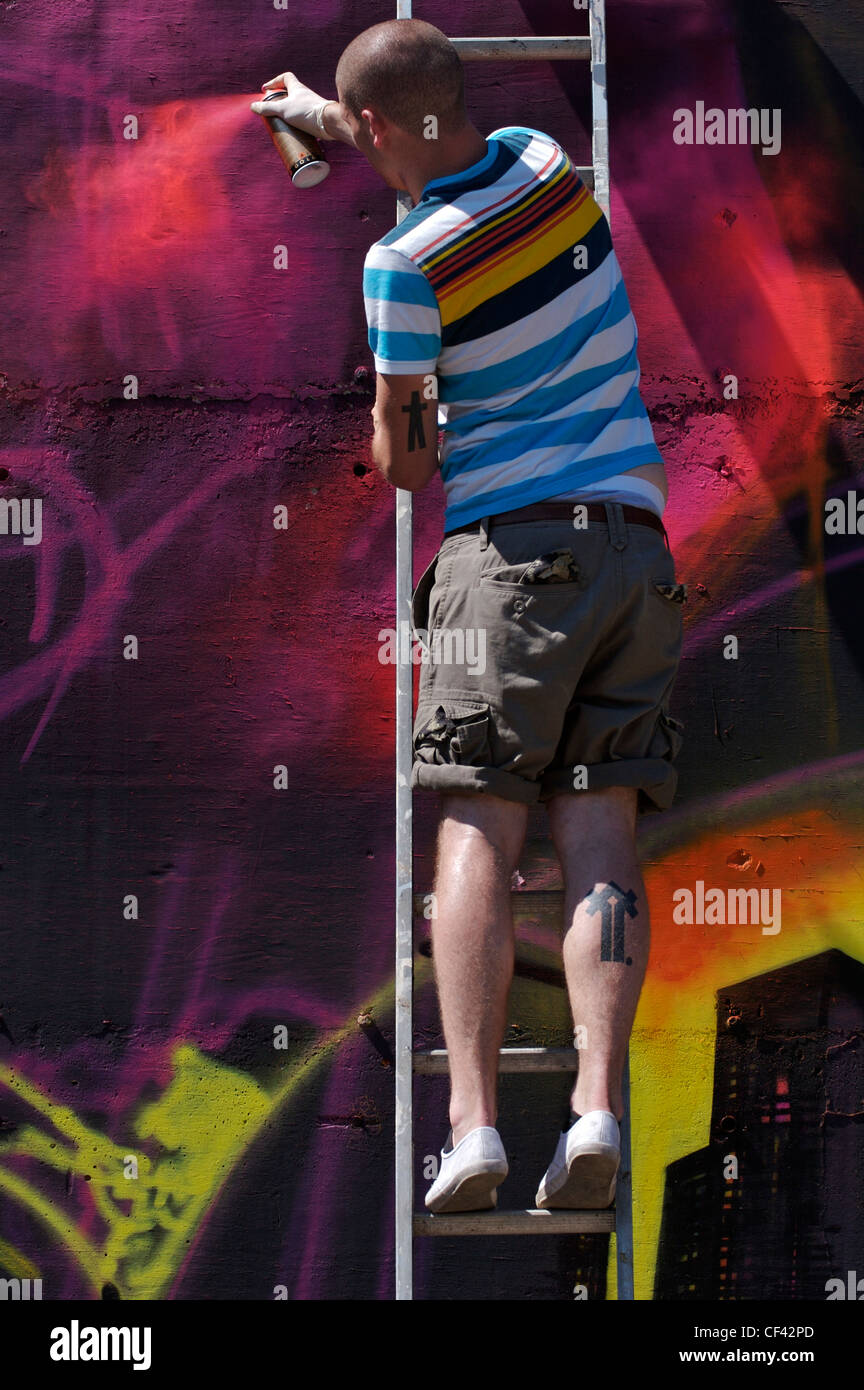 Ein Graffiti Kunstler Farben Von Einer Leiter Das Wort Graffiti Ist Der Plural Von Graffito Und Stammt Aus Dem Italienischen Wort G Stockfotografie Alamy