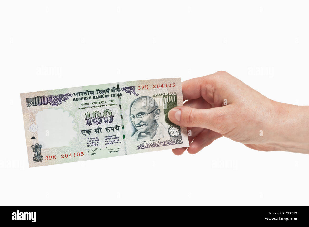 Eine indische 100 Rupien Rechnung mit dem Porträt von Mahatma Gandhi ist in der Hand, weißen Hintergrund gehalten. Stockfoto