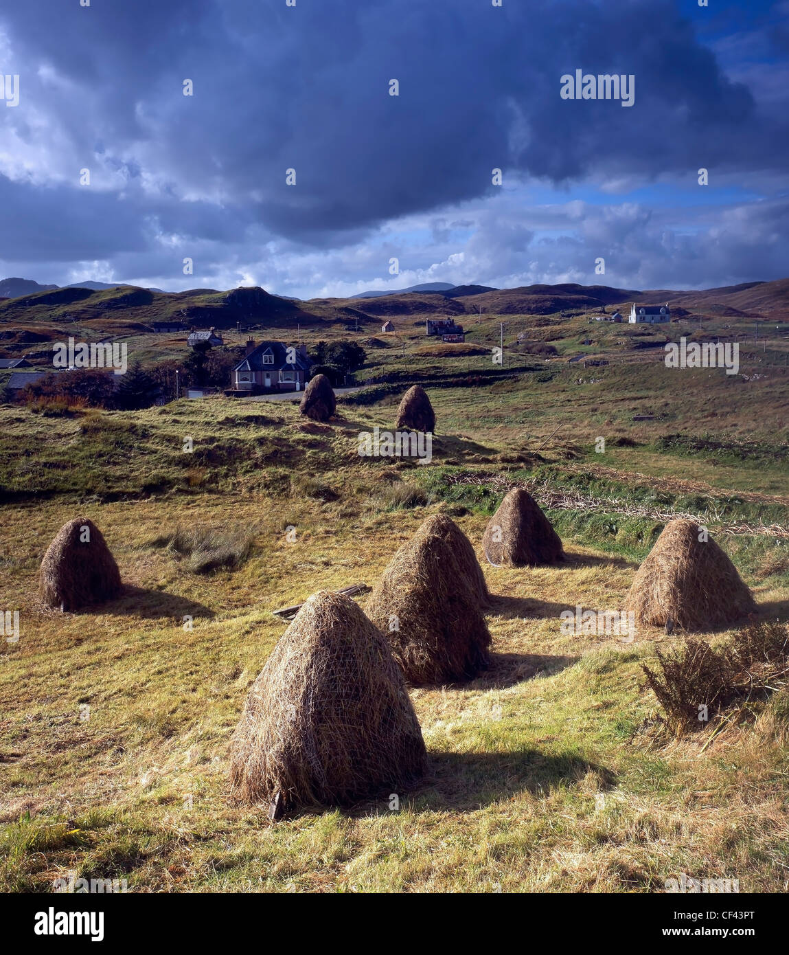 Blick über traditionelle, hand gesammelten Heuballen gegenüber der verstreuten Gemeinschaft von Lacasaidh auf der Isle of Lewis. Stockfoto