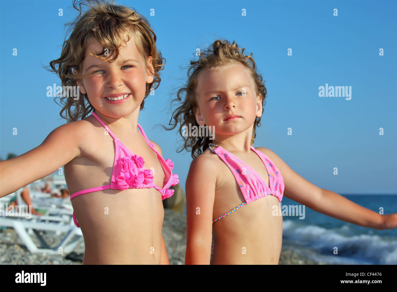 zwei hübsche Mädchen am Strand in der Nähe von Meer, legte die Hände in die Seiten Stockfoto