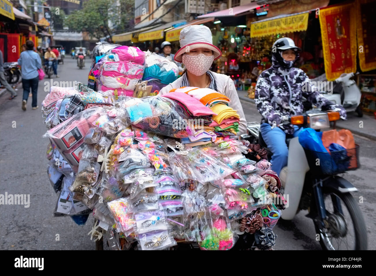 Frau mit Haushaltswäsche überlastet Fahrrad, Hanoi, Vietnam Stockfoto