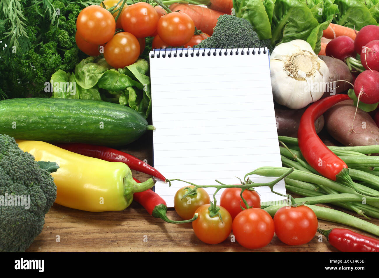 Einkaufsliste mit frischem Gemüse auf einem hölzernen Hintergrund regiert Stockfoto