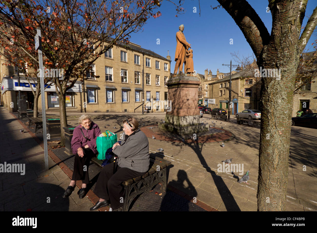 Zwei Frauen sitzen von der Statue von Richard Oastler, Northgate, Bradford. Stockfoto