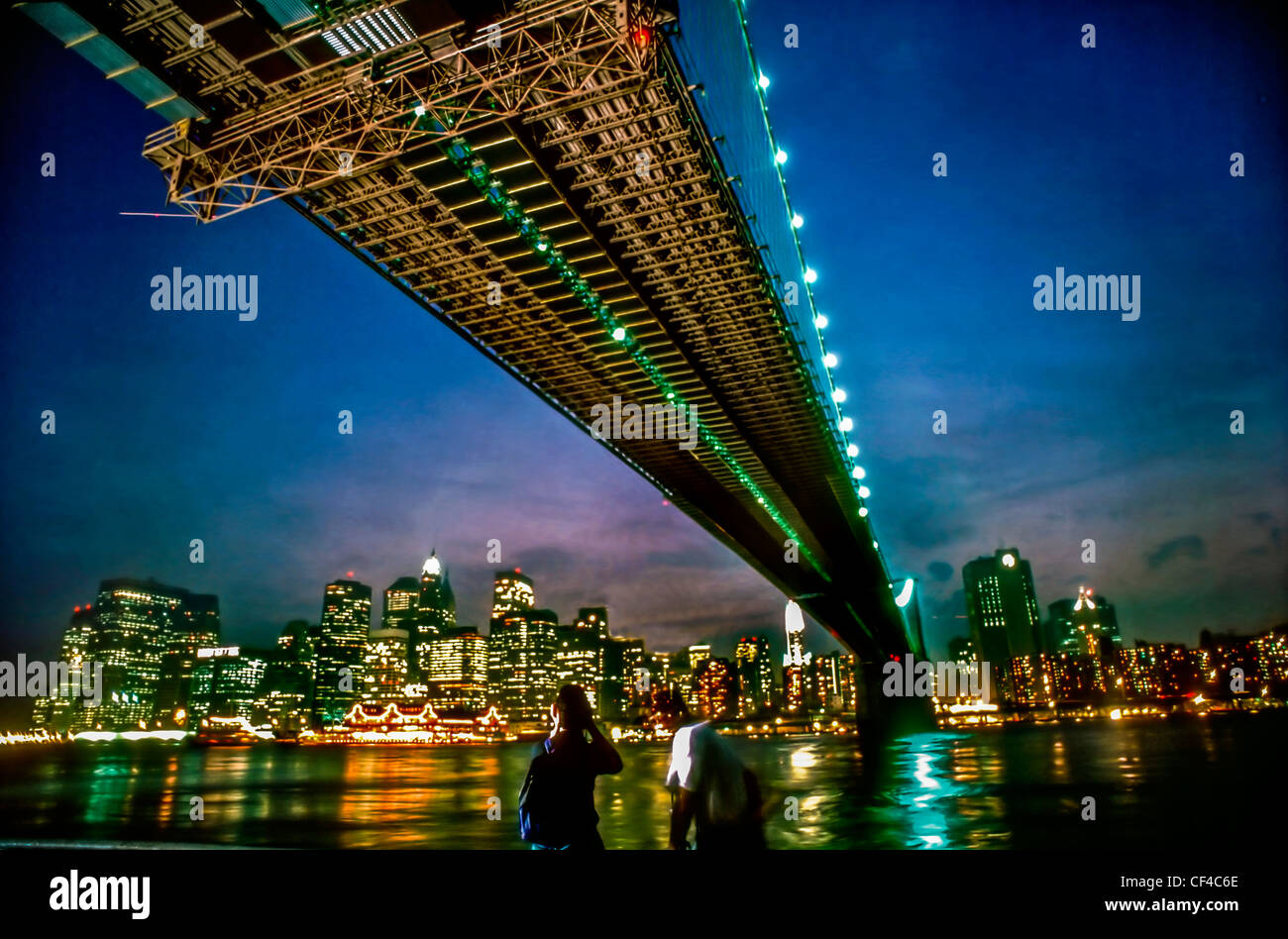 New York City, NY, USA - Nachtansicht des unter der Brooklyn Bridge Manhattan Skyline Stockfoto
